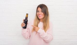 A pretty lady holding an alcohol