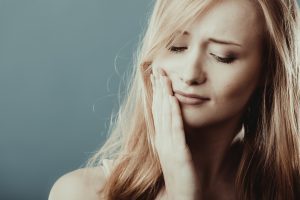 A lady experiencing from TMJ disorder