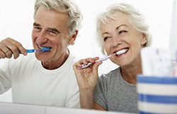 Old couple brushing their teeth